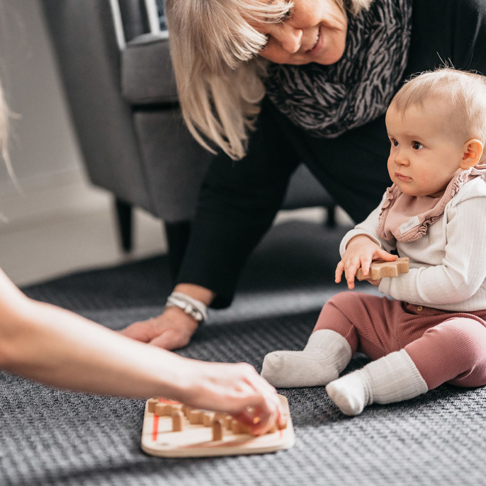 vuxna leker med ett barn på golvet